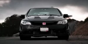 a black honda civic parked on a hill
